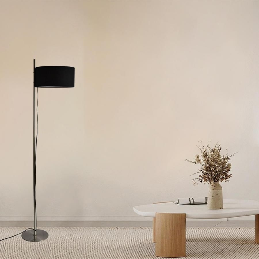 Modern black shade floor lamp with nickel finish, displayed in a warm minimalist living room setting