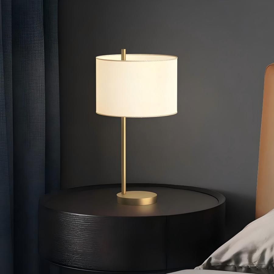 Minimalist brass table lamp on bedroom nightstand, modern bedside lamp with drum fabric shade